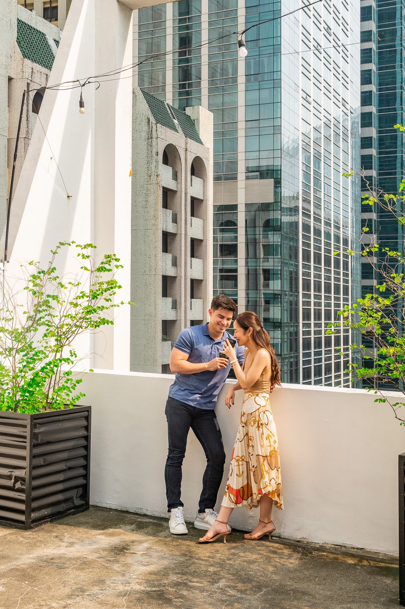 Couple smiling on rooftop terrace with Makati CBD skyline views