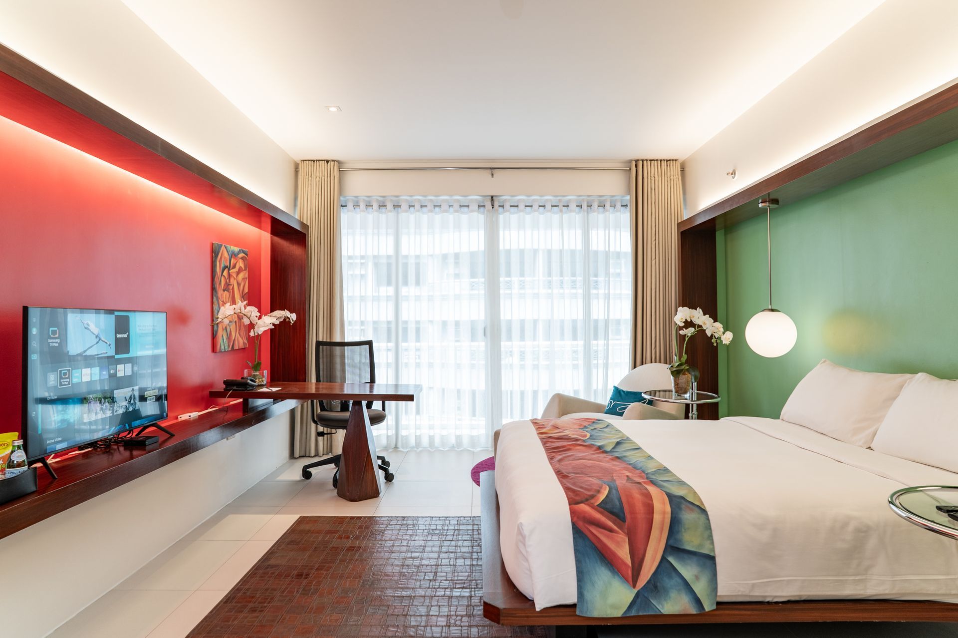 A hotel room with a large bed and a flat screen tv