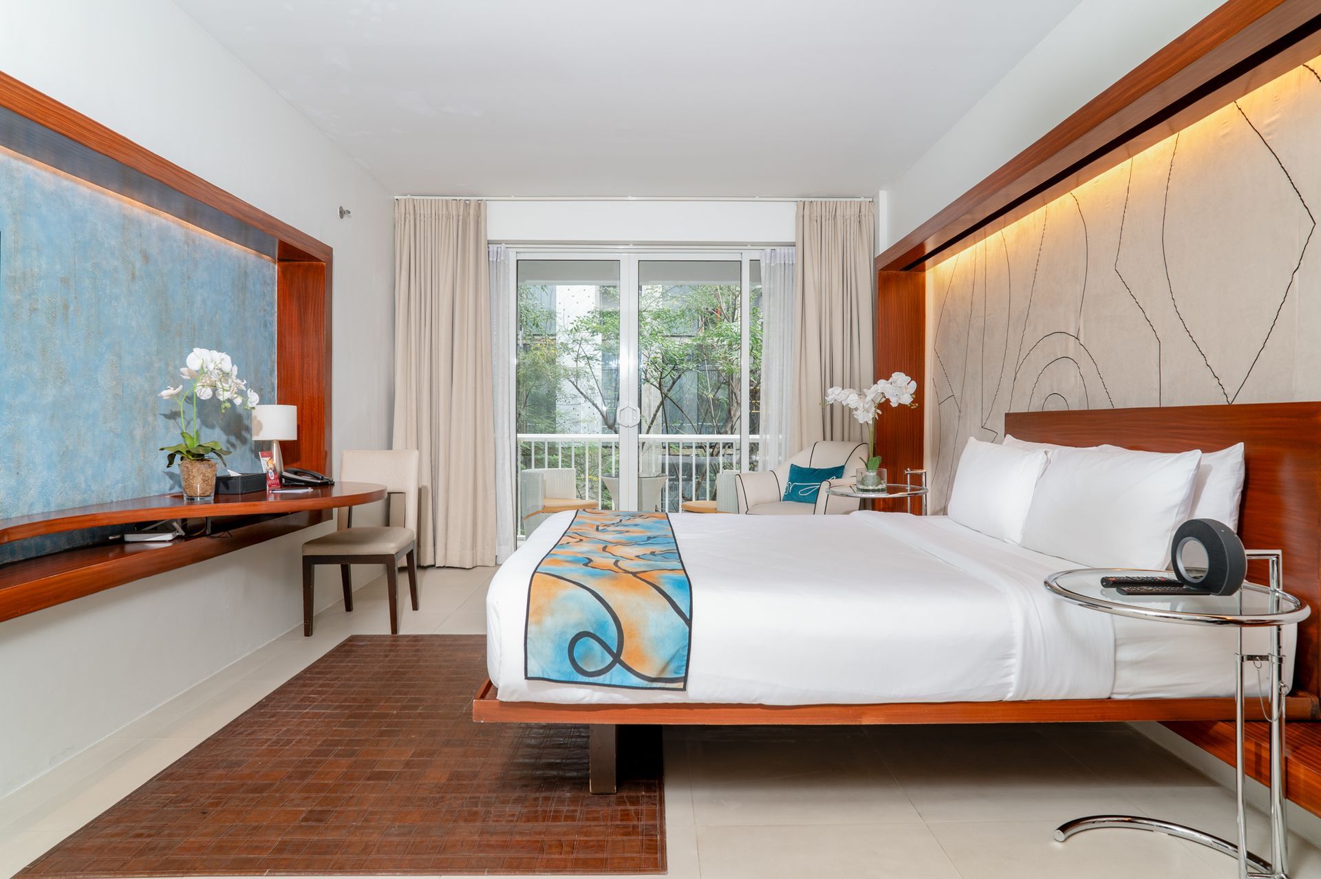 A hotel room with a large bed and a sliding glass door
