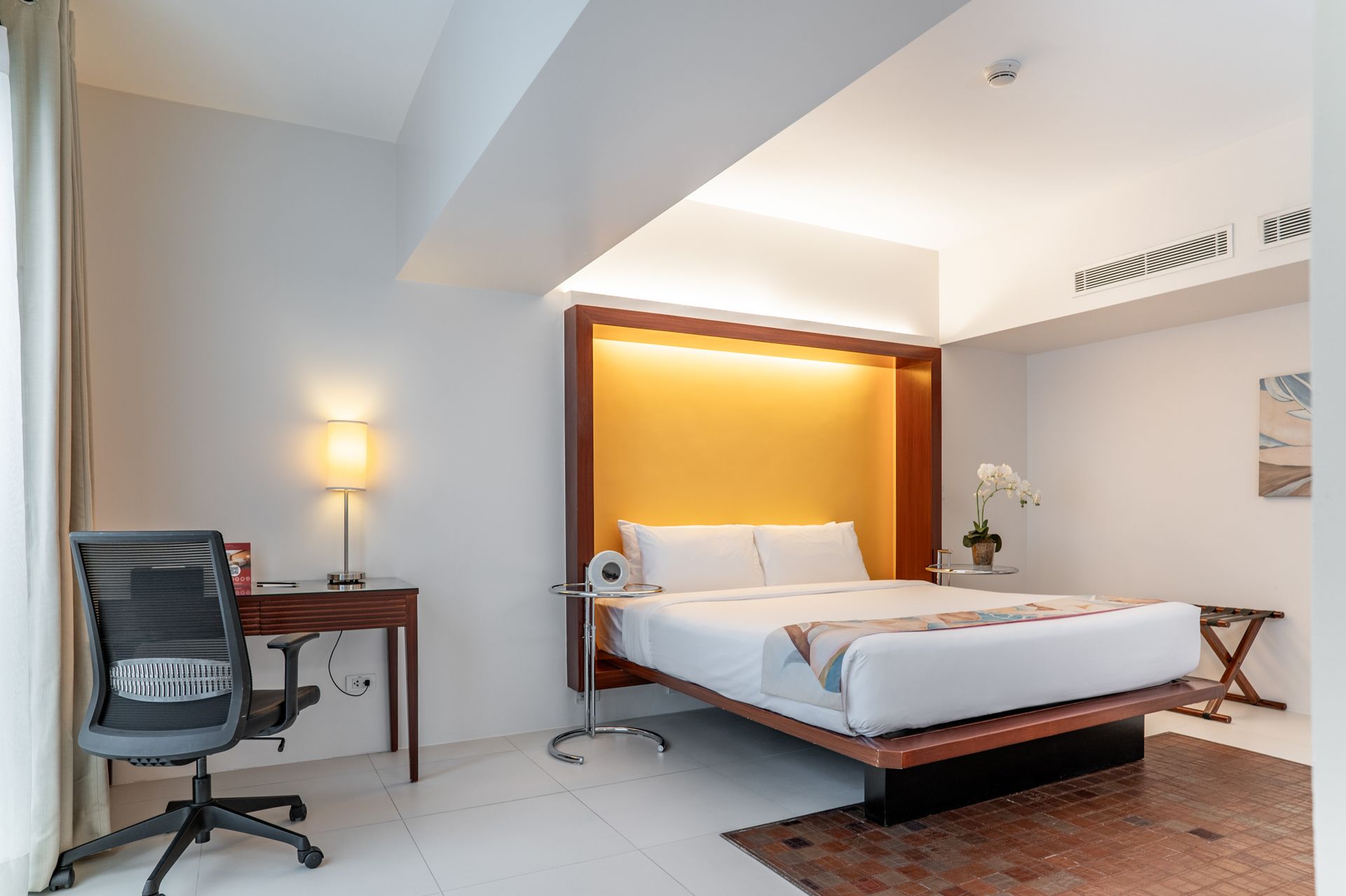 A hotel room with a large bed and a desk