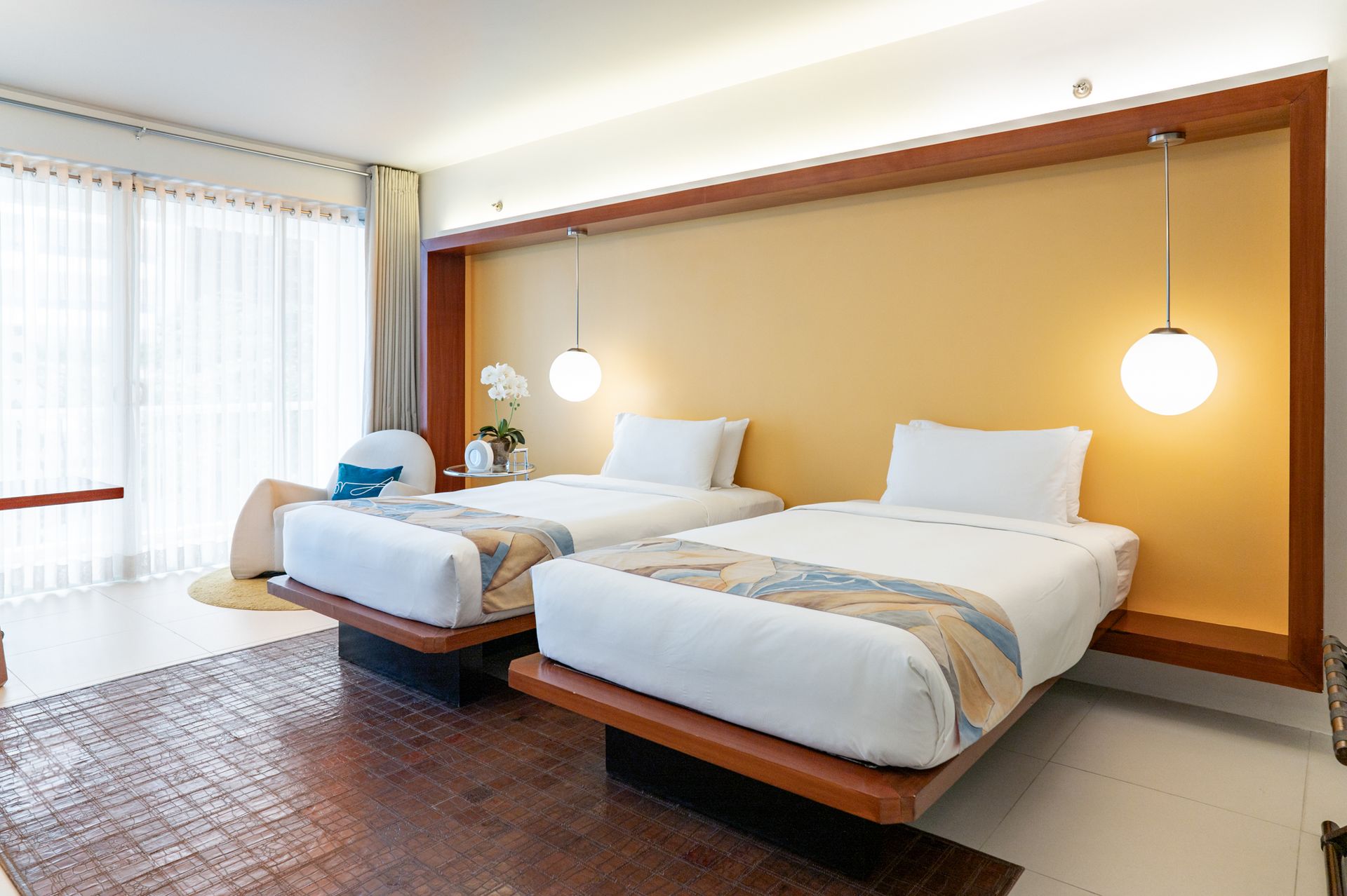 A hotel room with two beds and a large window
