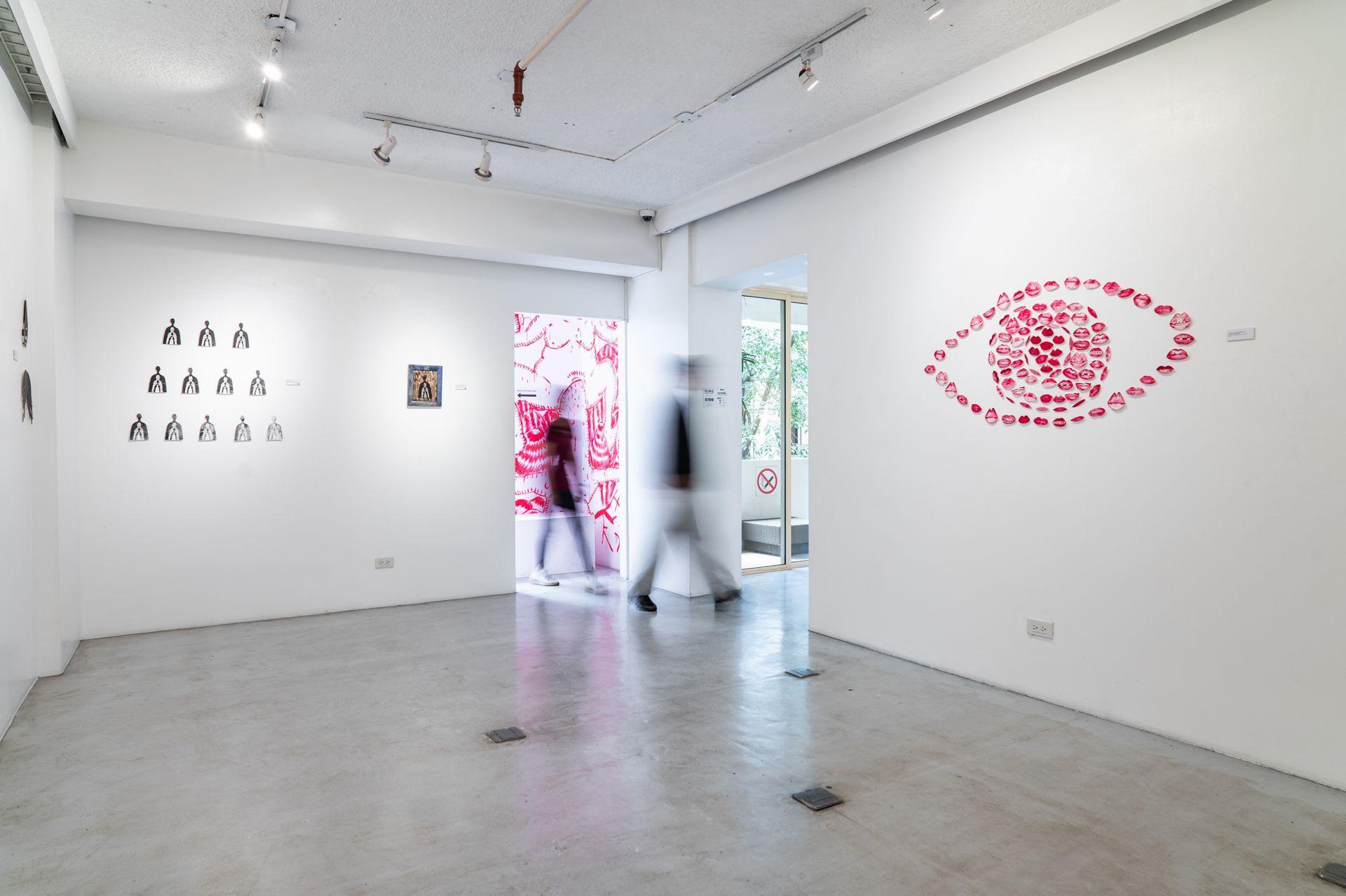 Minimalist art gallery with white walls, red wall art, and a person standing near the doorway