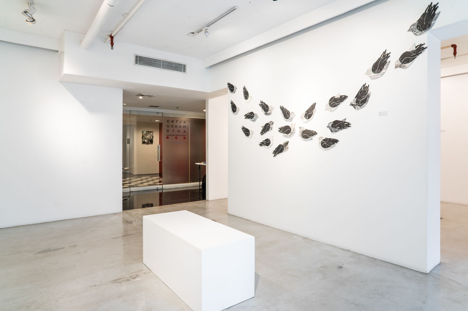 Contemporary art gallery installation with bird-like wall sculptures