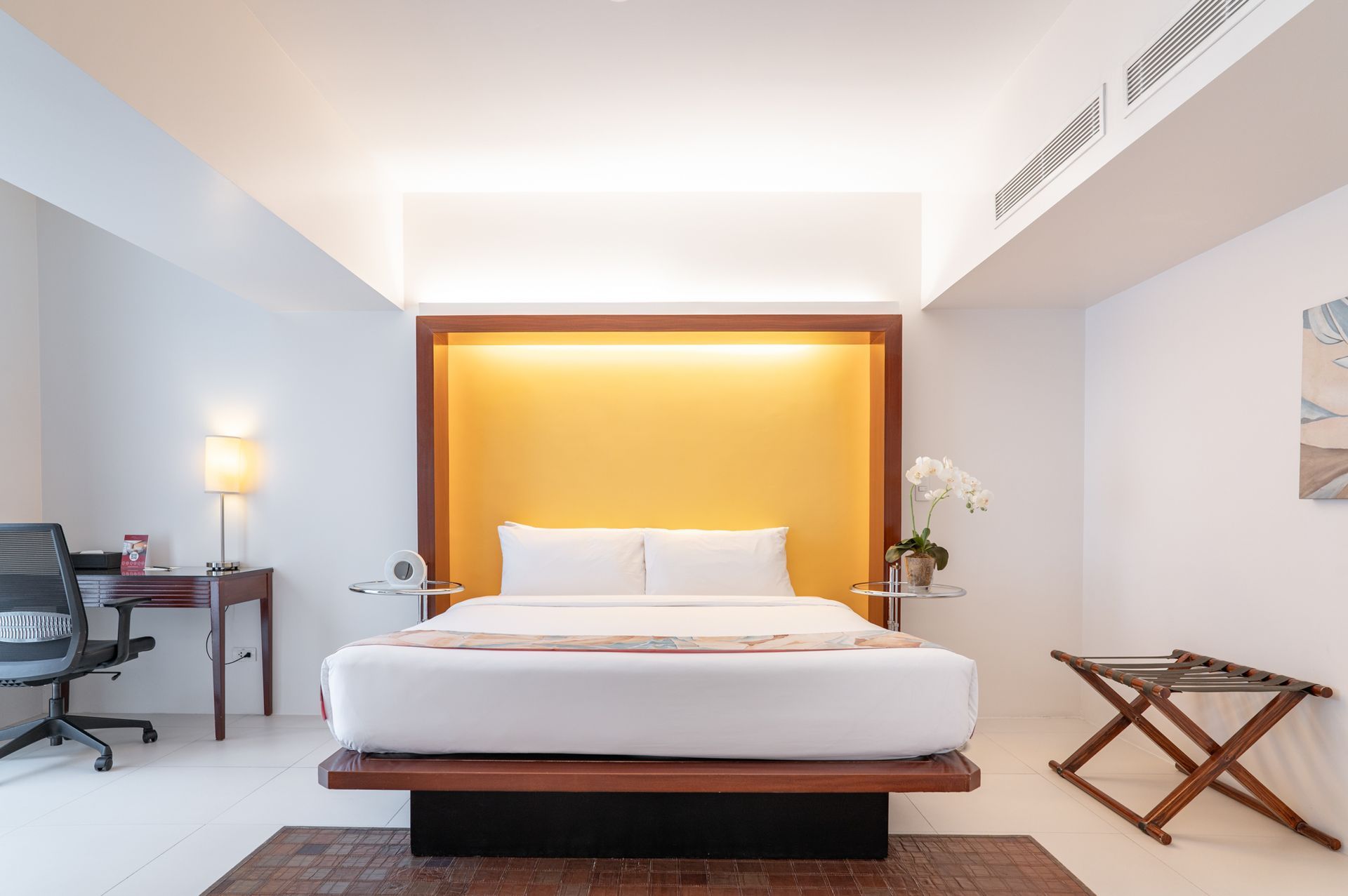 A hotel room with a large bed and a desk