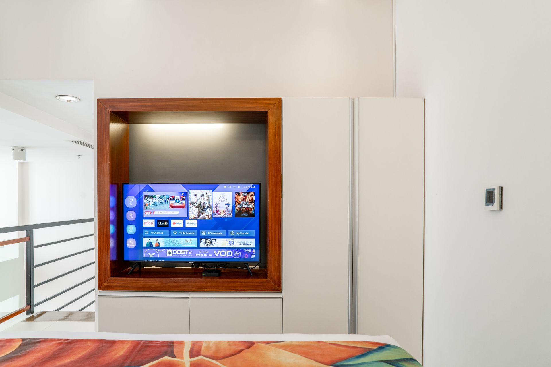 Smart TV in wooden niche in modern bedroom at Picasso Boutique Residences