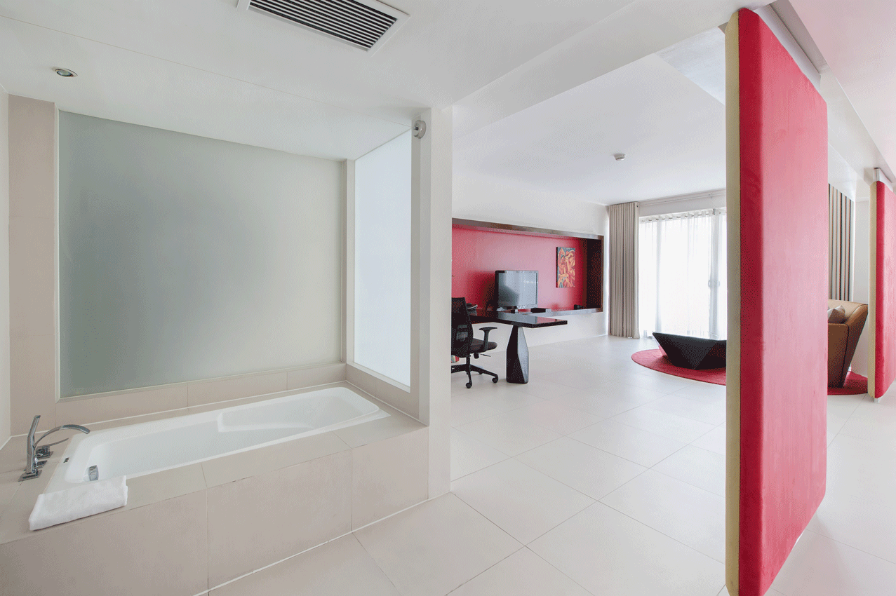 Minimalist bedroom with red accent wall in boutique serviced residences.