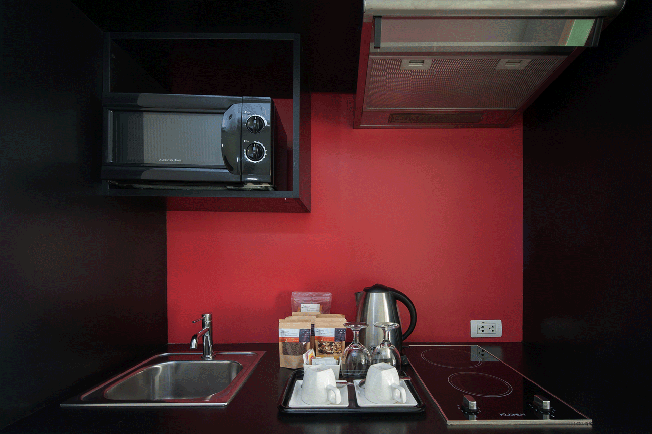 Living area with red accent kitchenette  perfect for meal prep