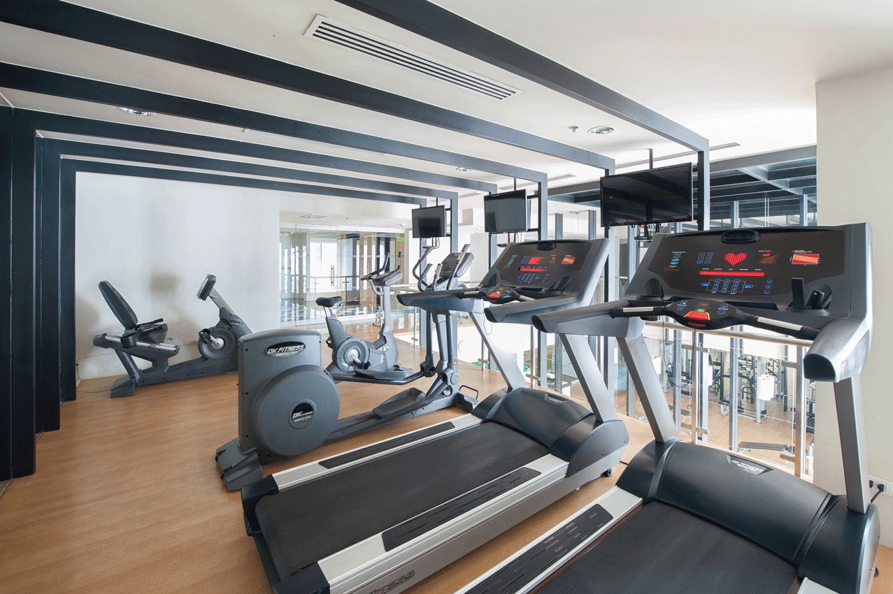 Modern fitness center with equipment and floor-to-ceiling windows in boutique serviced residences Makati.
