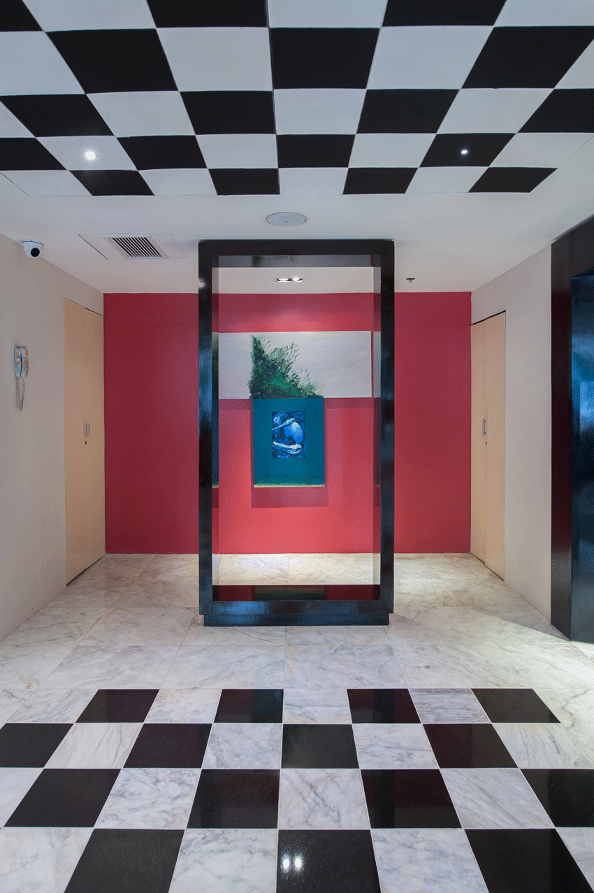 Bold black-and-white checkered lobby with red accent wall art display
