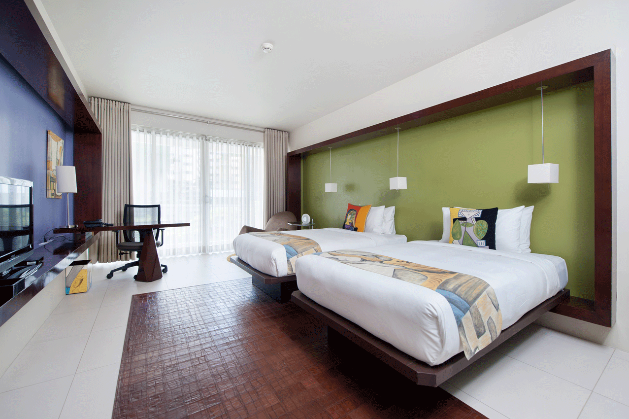 Bedroom with green wall and equipped kitchenette in serviced residences Makati