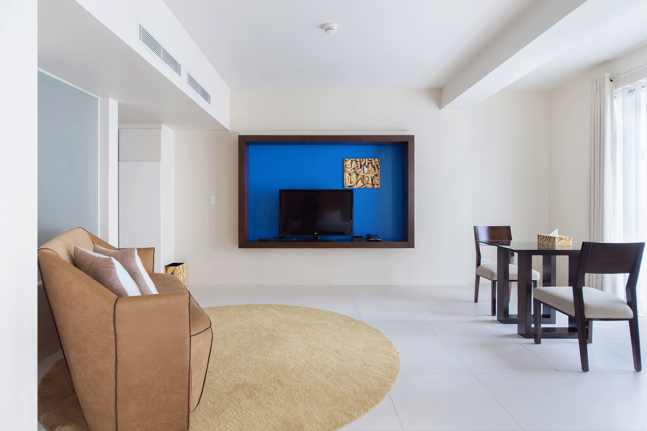 Living room with blue wall-mounted TV in family-friendly boutique hotel.