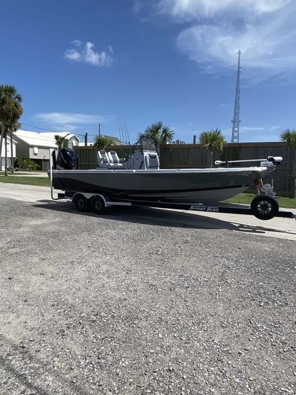 A boat is sitting on a trailer in a parking lot.