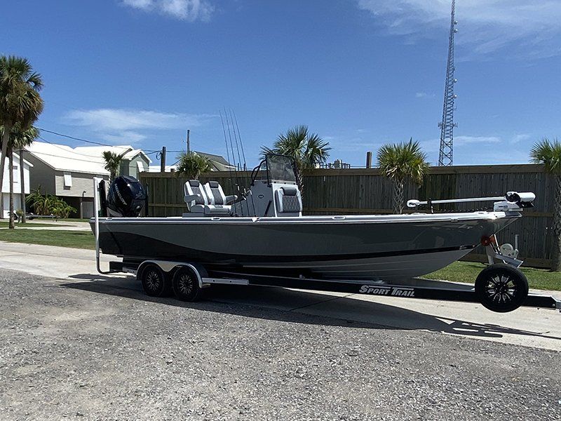 A boat is parked on the side of the road on a trailer.