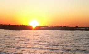 The sun is setting over a body of water.