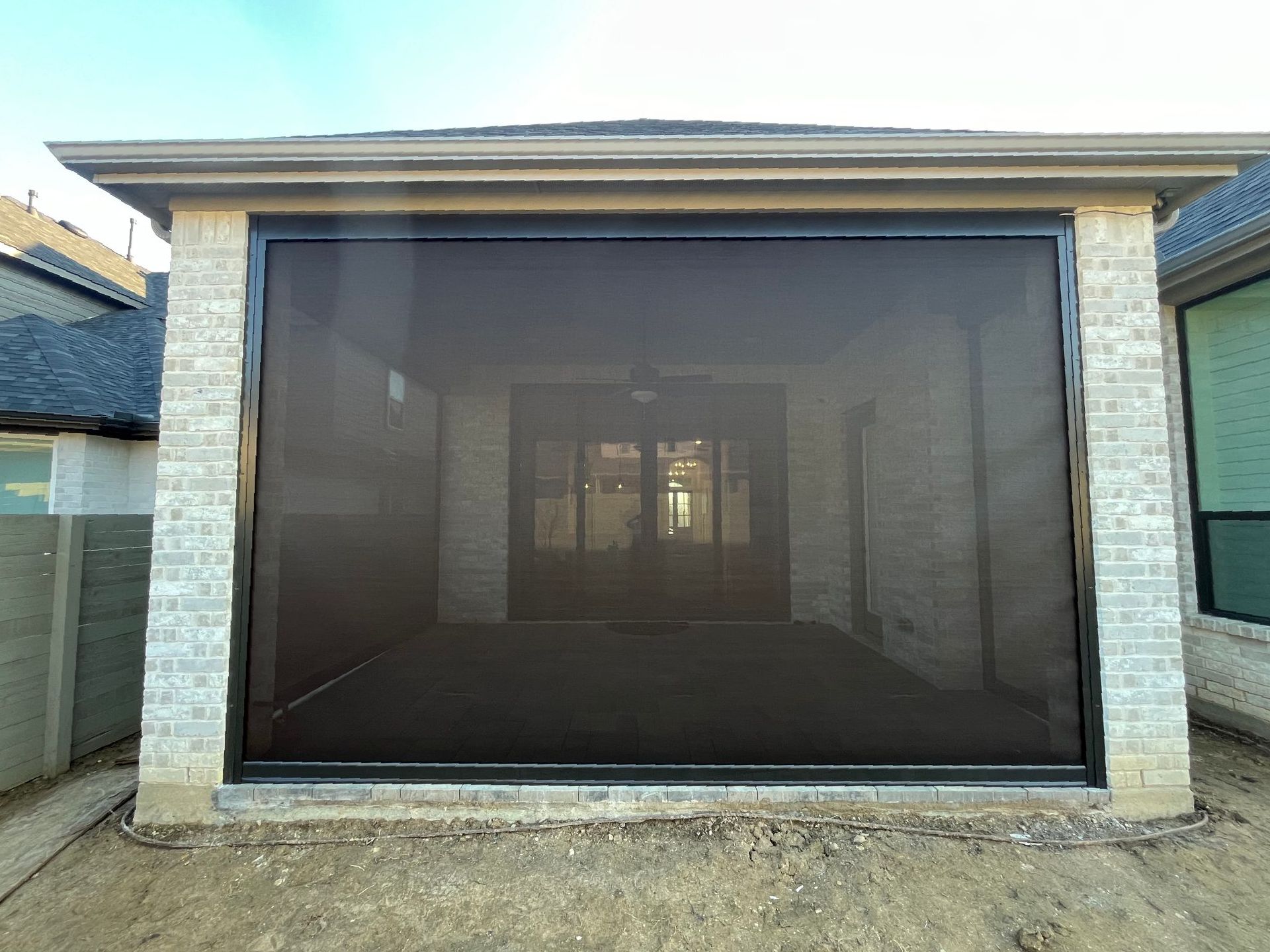 A brick building with a screen door on the side of it.