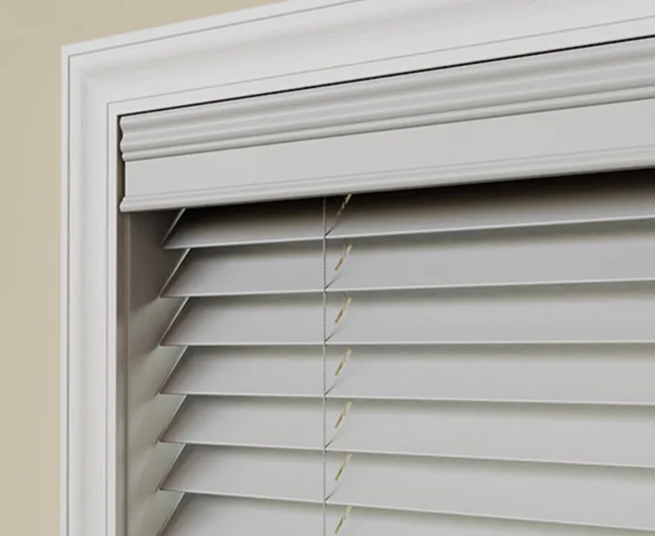 A close up of a white blind on a window