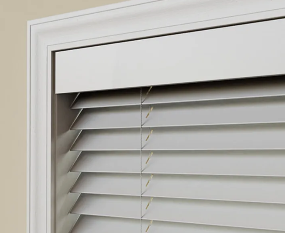 A close up of a white blind on a window