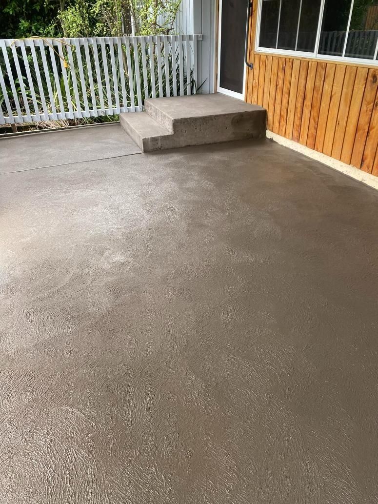 Empty Concrete Patio With a Small Step, White Railing, and Wooden Fence — BJ's Concreting in Bomaderry, NSW
