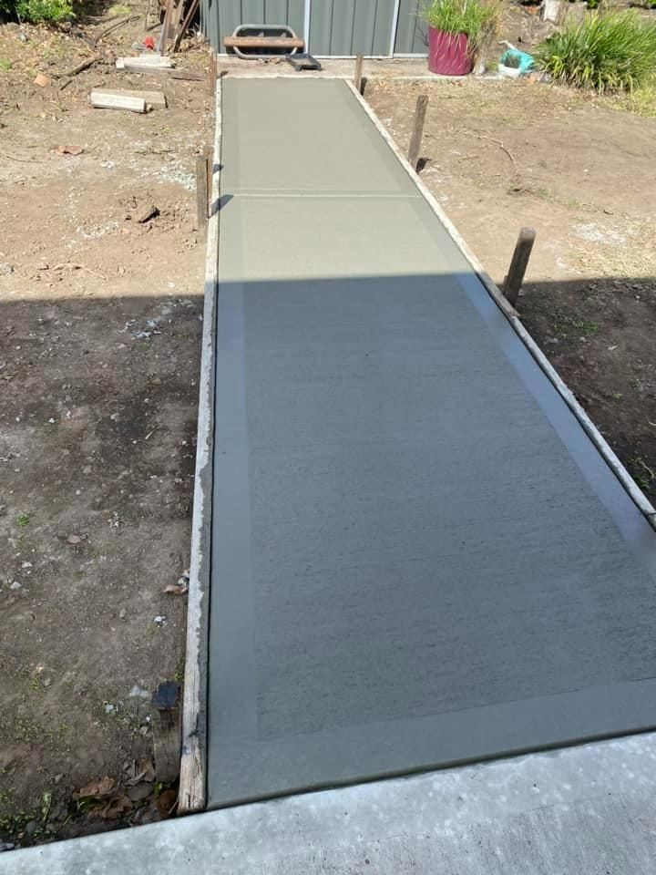 Outdoor Gray Metal Ramp Leading to a Shed Entrance in a Yard — BJ's Concreting in Callala Bay, NSW