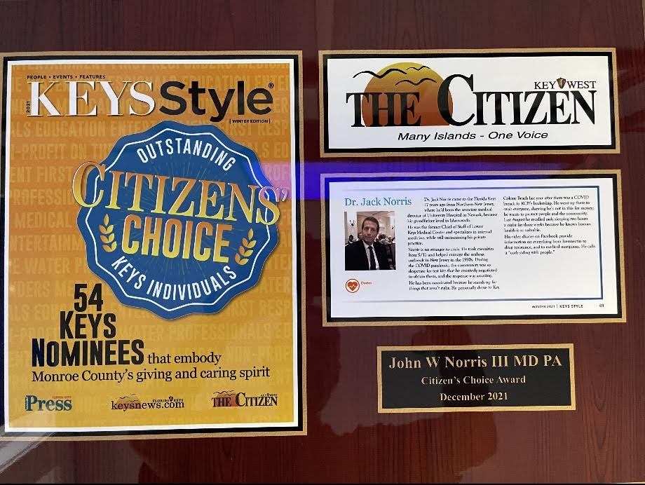 Plaque honoring John W. Norris III, MD, PA, with a newspaper cover and article. 