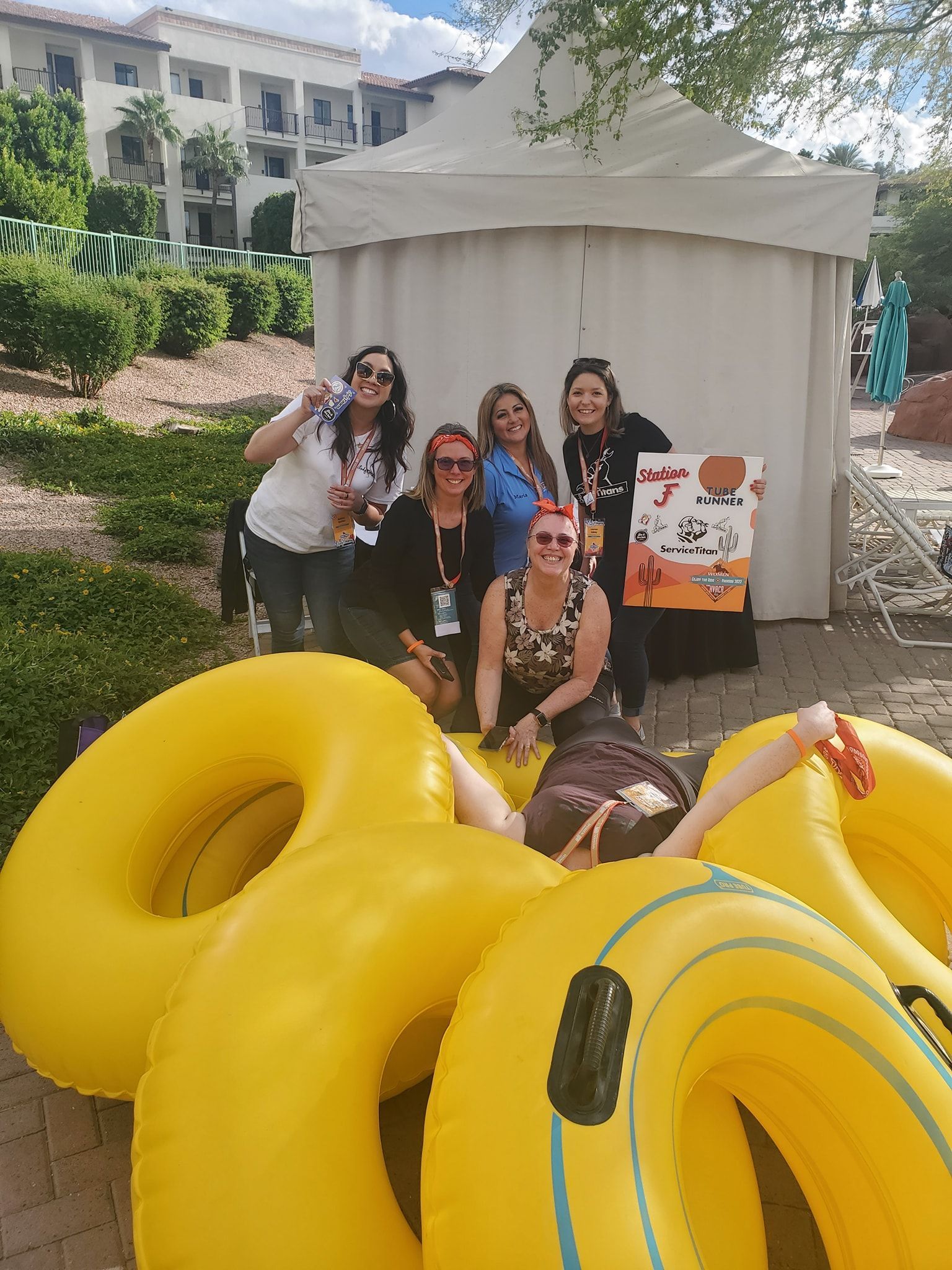 A group of women are posing for a picture while sitting on yellow inflatable tubes.