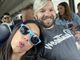 A man and a woman wearing sunglasses are posing for a picture on a bus.