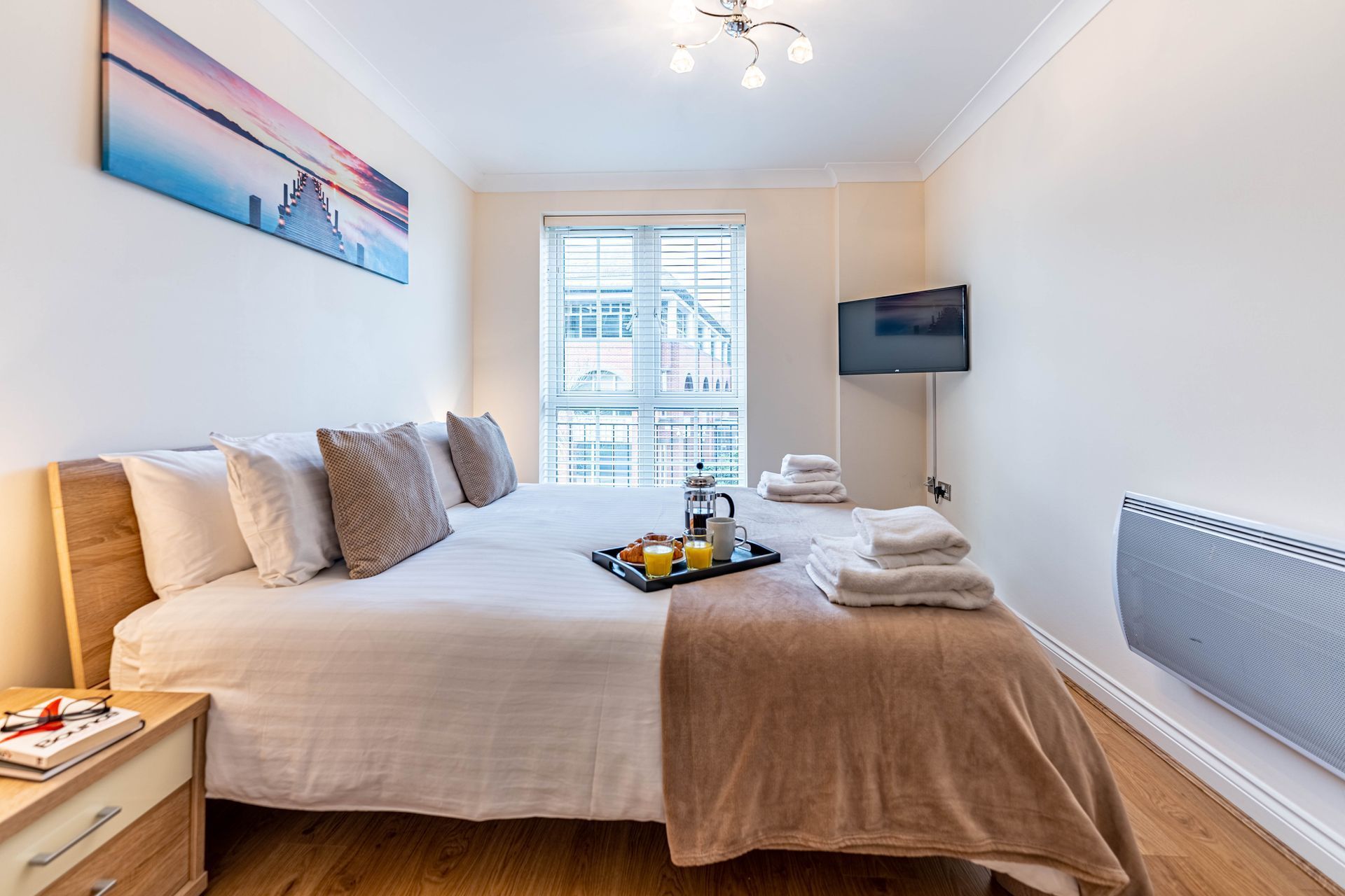 Riverside house master bedroom with folded towels on the bed and a breakfast tray 