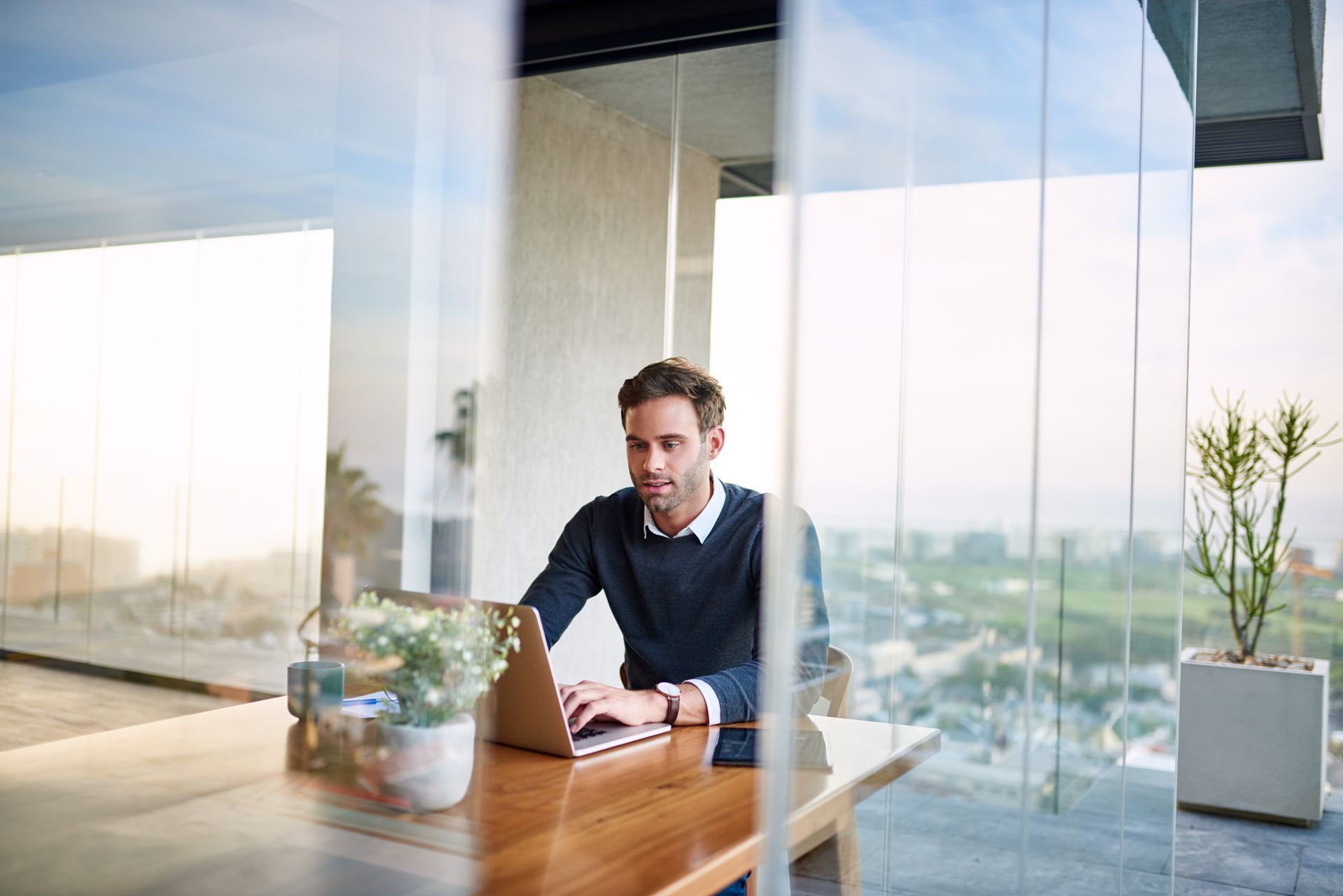 A business professional sitting and working on a laptop in a serviced apartment in Reading