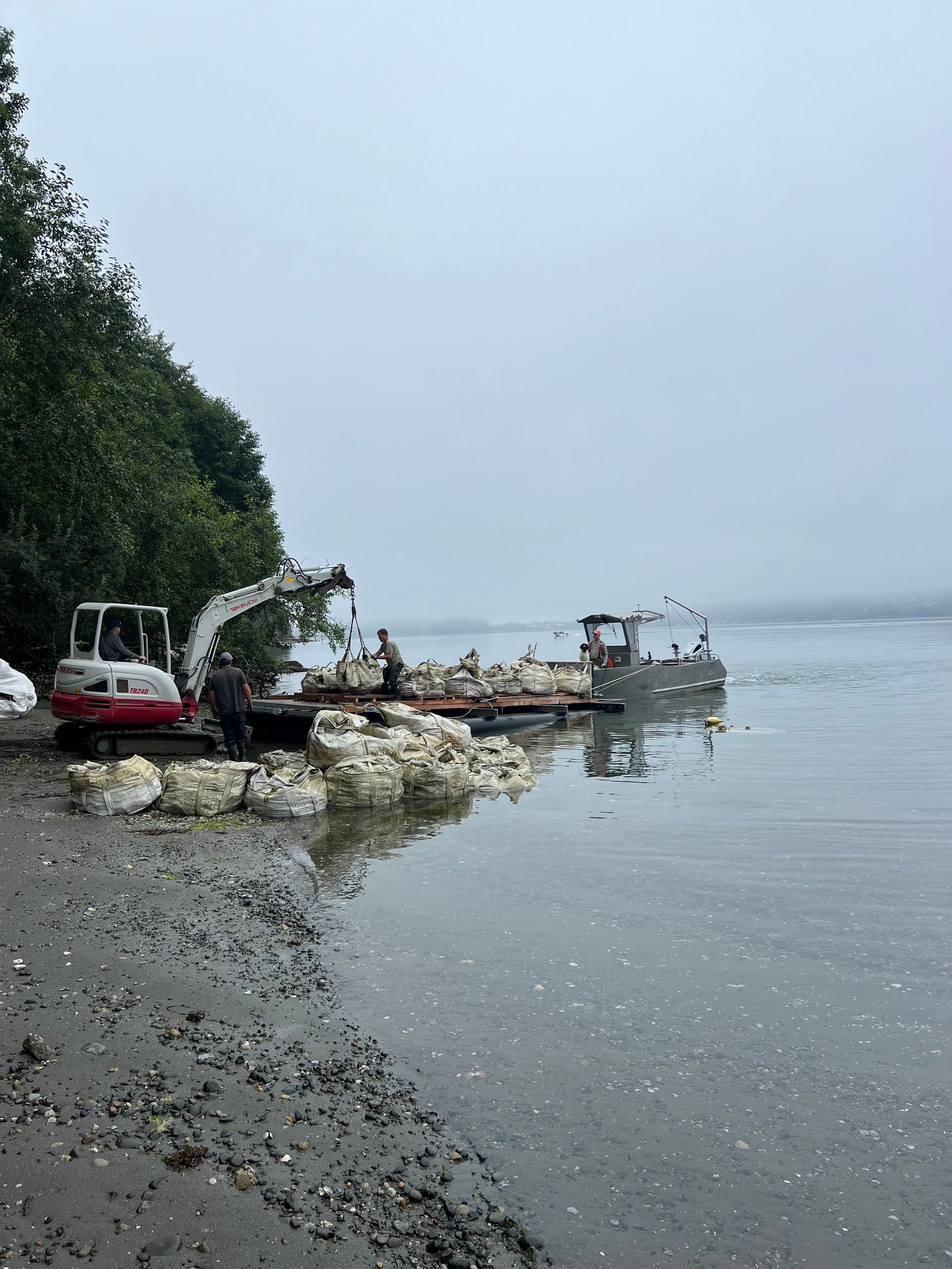 Work barge moored at new dock structure with crew on deck