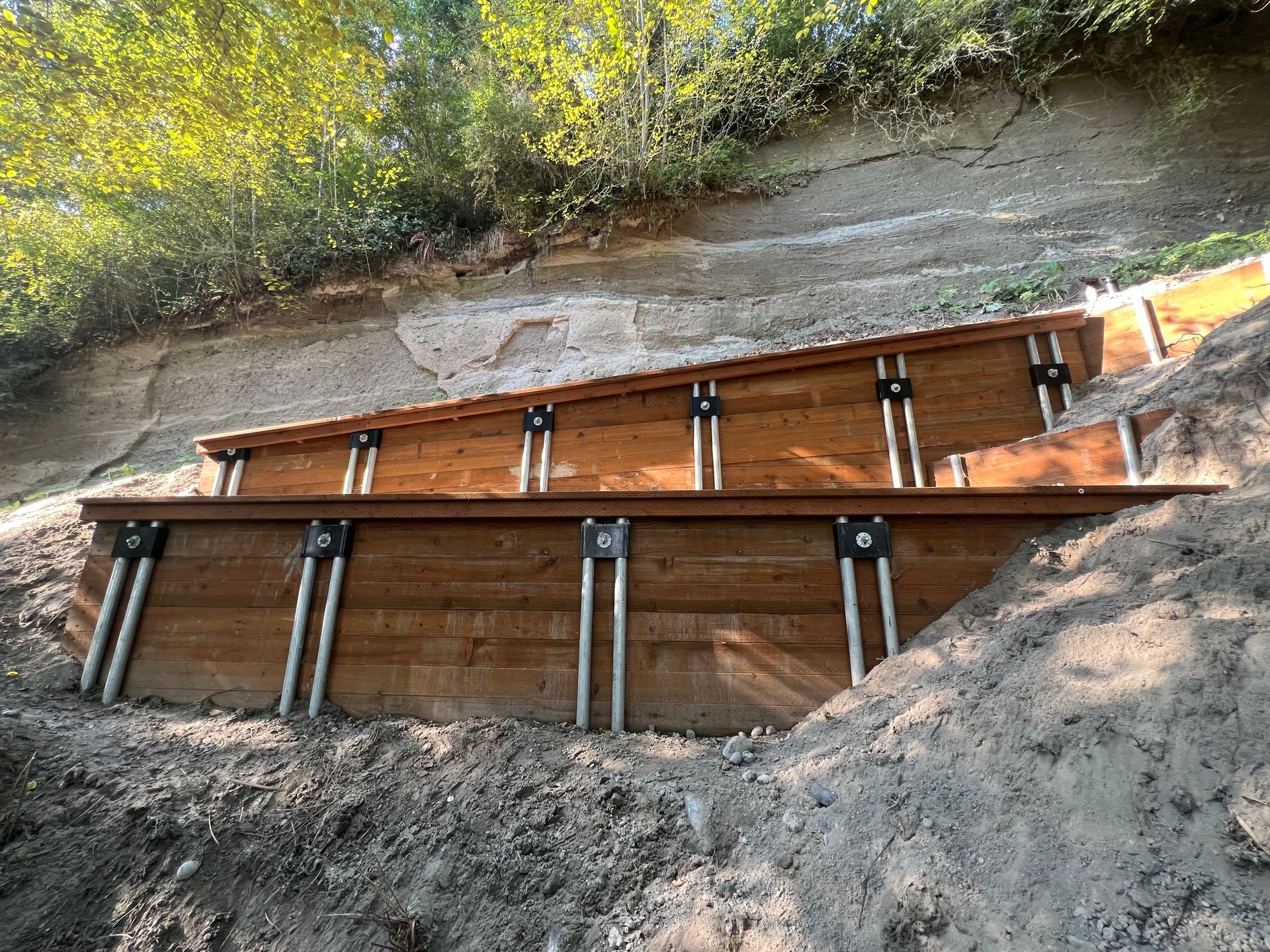 Close-up of steel pin pile head to timber lagging cap connection with hardware