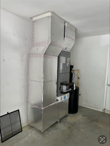 Metal utility cabinet with vented panels beside a black trash can in a bare room