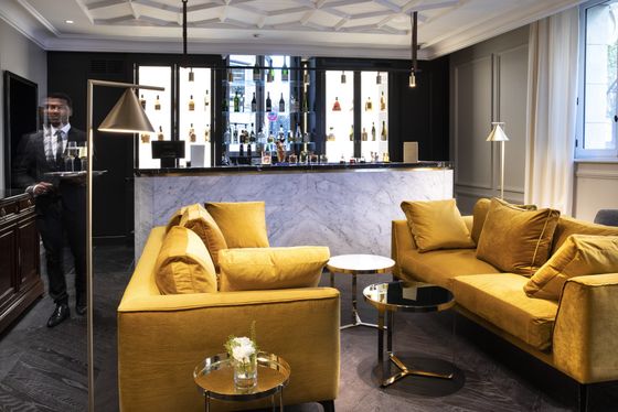 Un salon avec des canapés jaunes et un bar en arrière-plan