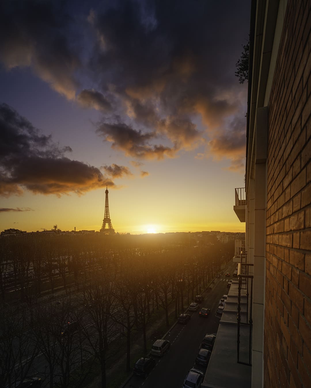 Une vue de la tour Eiffel au coucher du soleil depuis un balcon