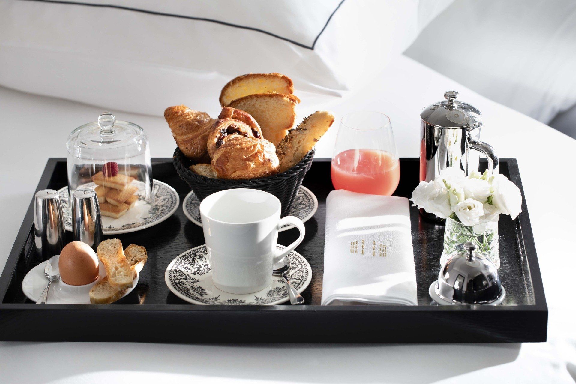 Un plateau avec une tasse de café et des croissants dessus