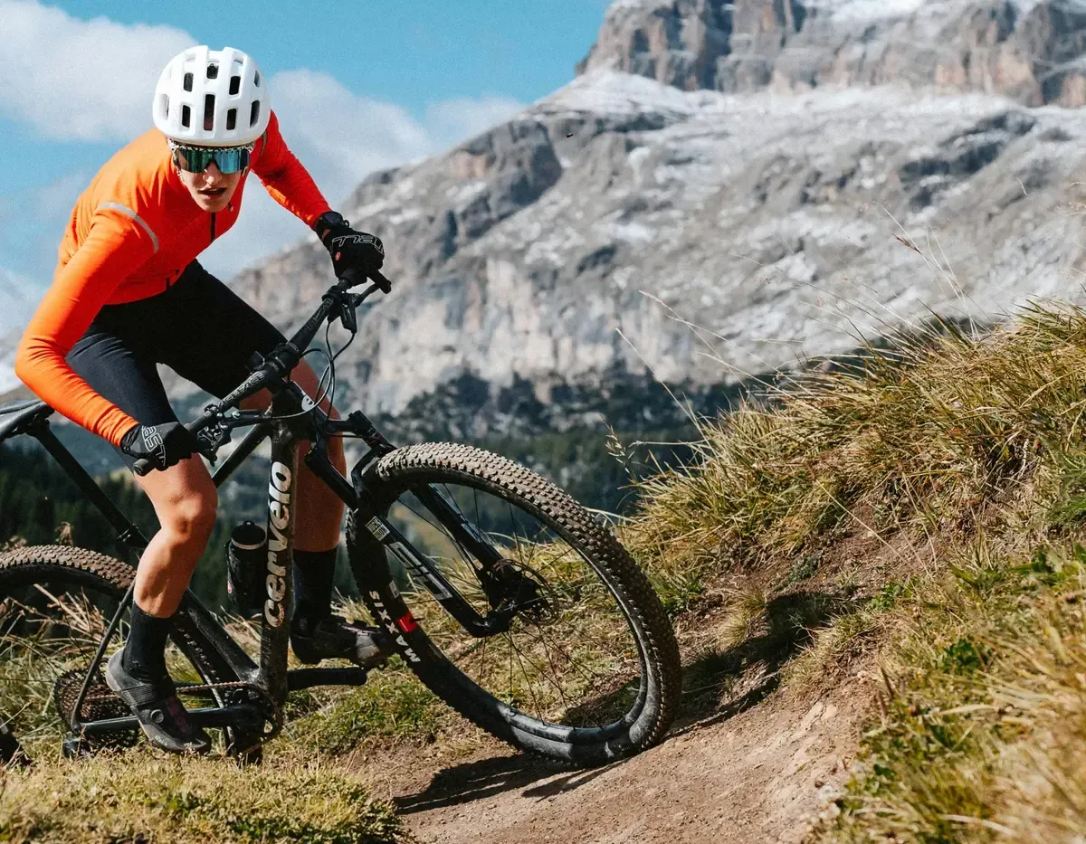 A Man Is Riding A Mountain Bike Down A Dirt Trail — Trinity Cycle Works In Cairns City, QLD