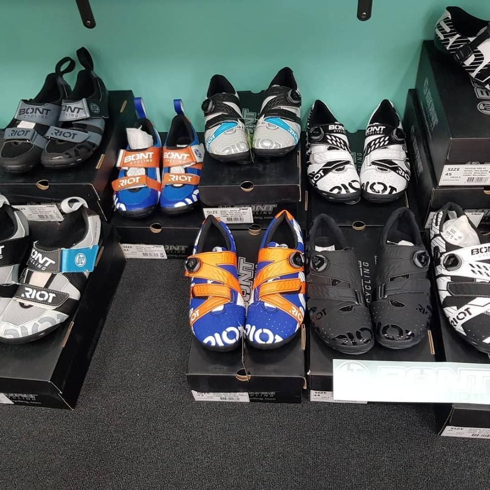 Several Pairs Of Cycling Shoes Are Lined Up On A Shelf — Trinity Cycle Works In Cairns City, QLD