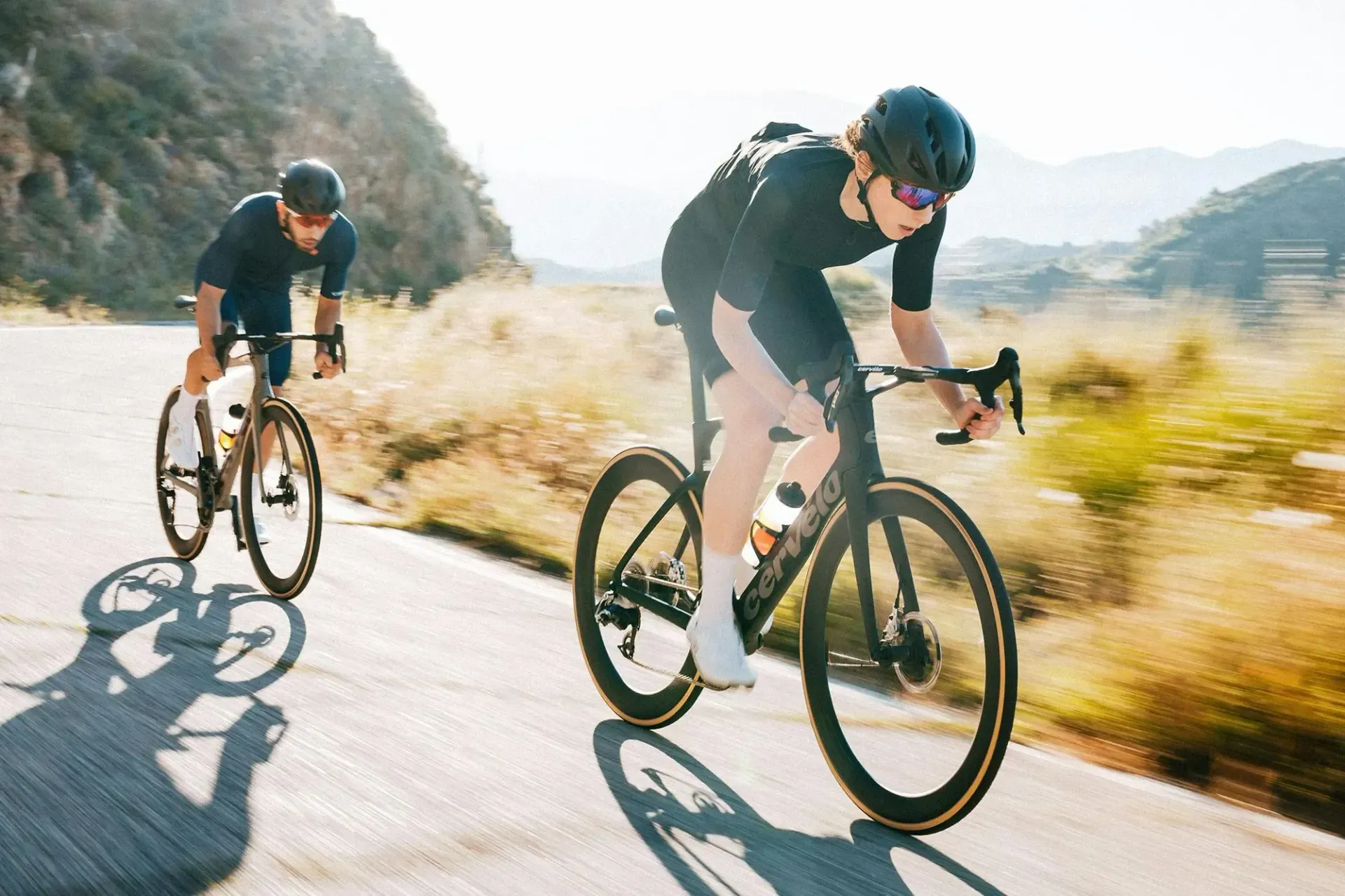 Two People Are Riding Bicycles Down A Road — Trinity Cycle Works In Cairns City, QLD