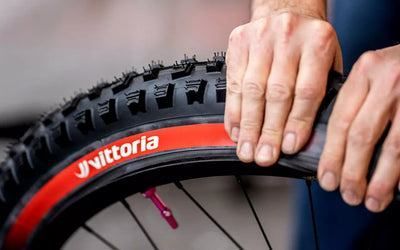 A Person Is Putting A Tire On A Bicycle Wheel — Trinity Cycle Works In Cairns City, QLD