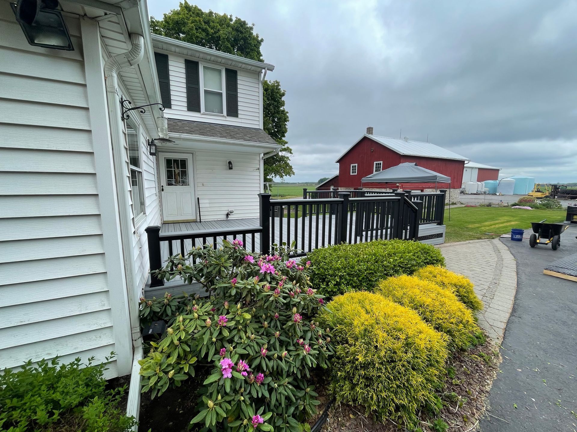 A white house with a red barn in the background