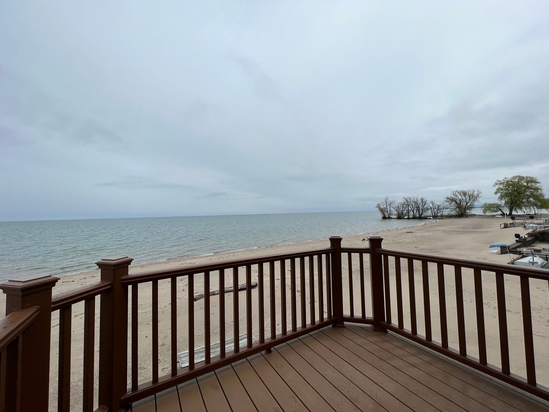 A wooden deck overlooking a beach and the ocean.
