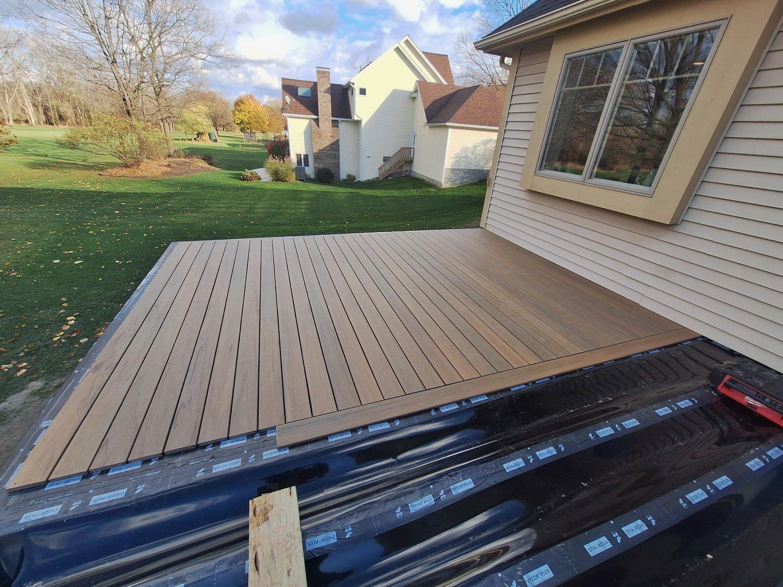 A wooden deck is being built in front of a house.