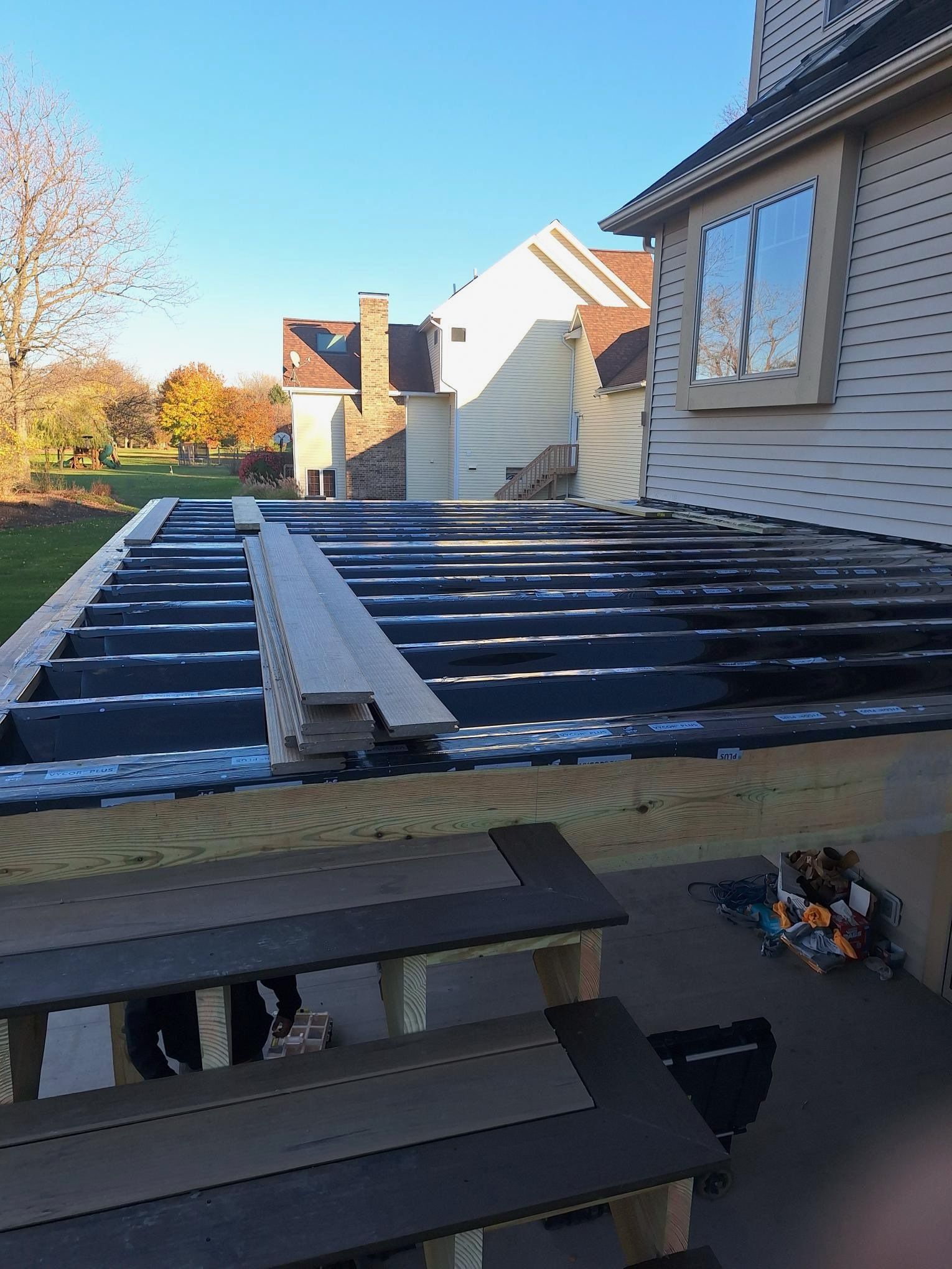 A wooden deck is being built in front of a house.