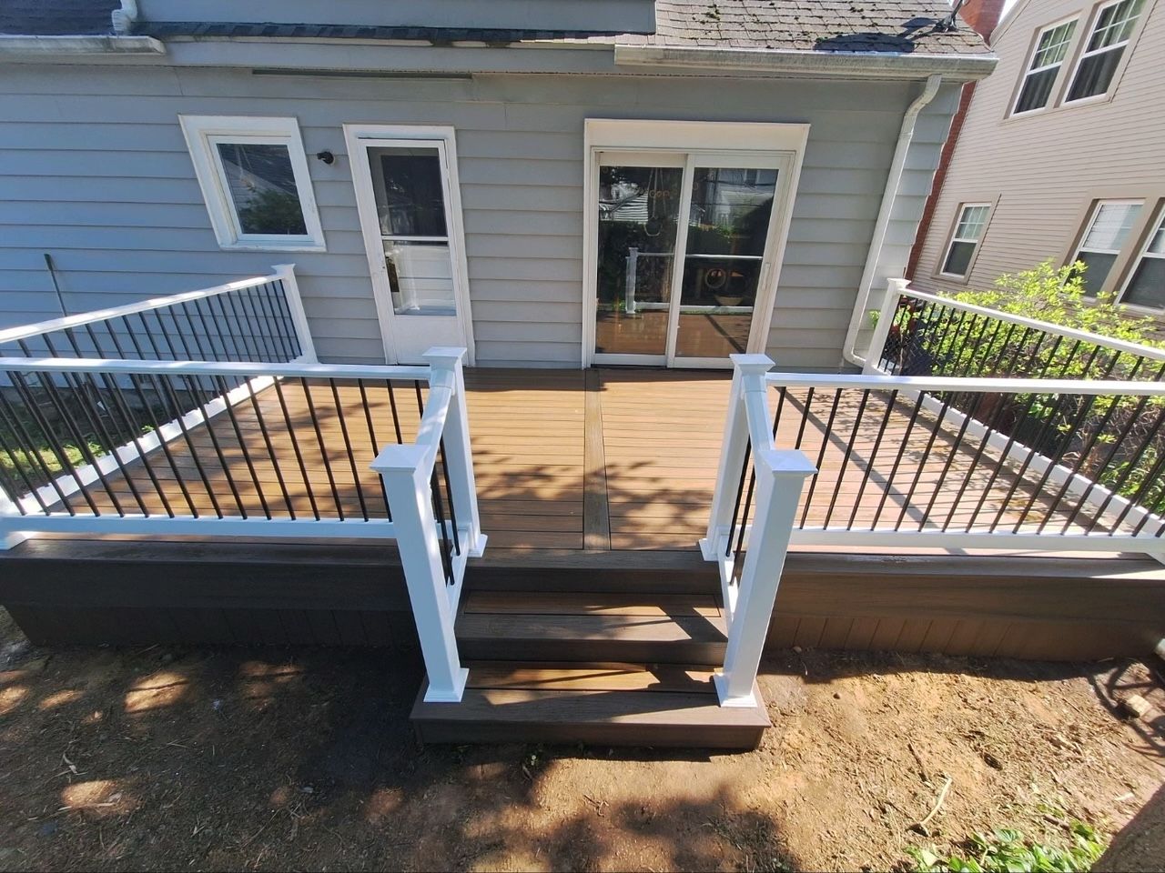 A house with a deck and stairs leading to it.