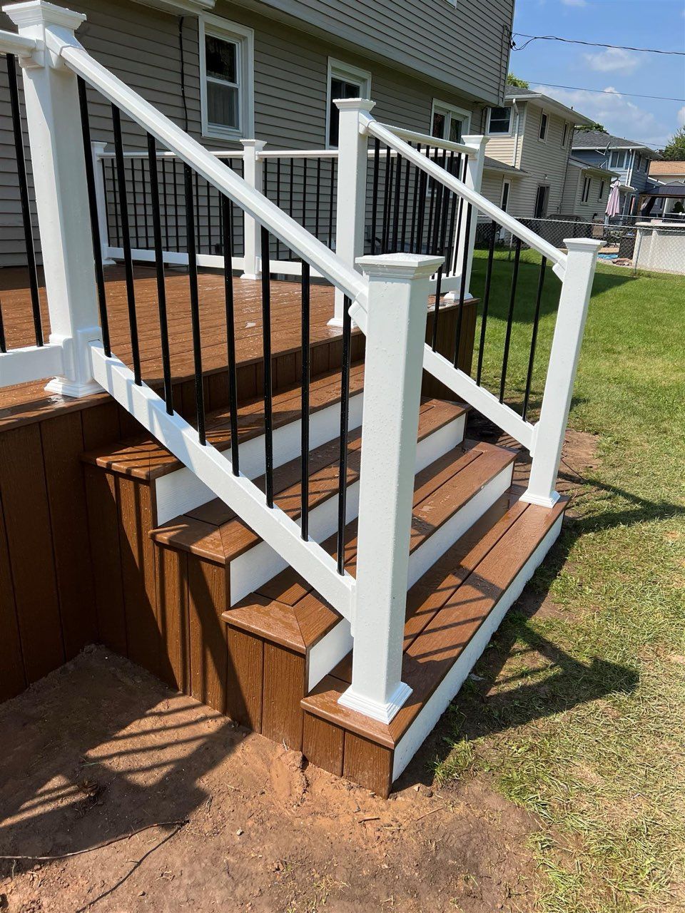 A wooden deck with stairs and a white railing