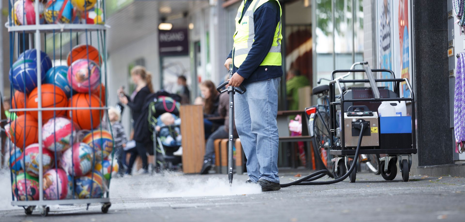 Bike repair station beside a street, with a worker and colorful balls stacked in a wire cart
