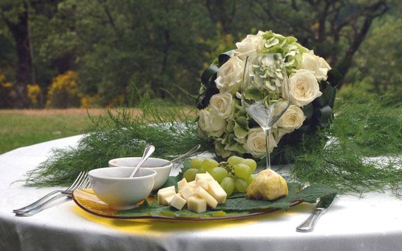 Un tavolo con un mazzo di fiori e cibo per un evento