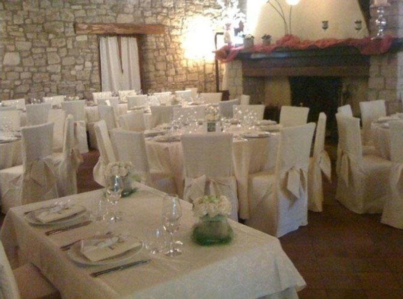Una stanza piena di tavoli e sedie e un caminetto