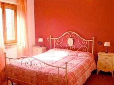 Una camera con un letto, due comodini e una finestra.