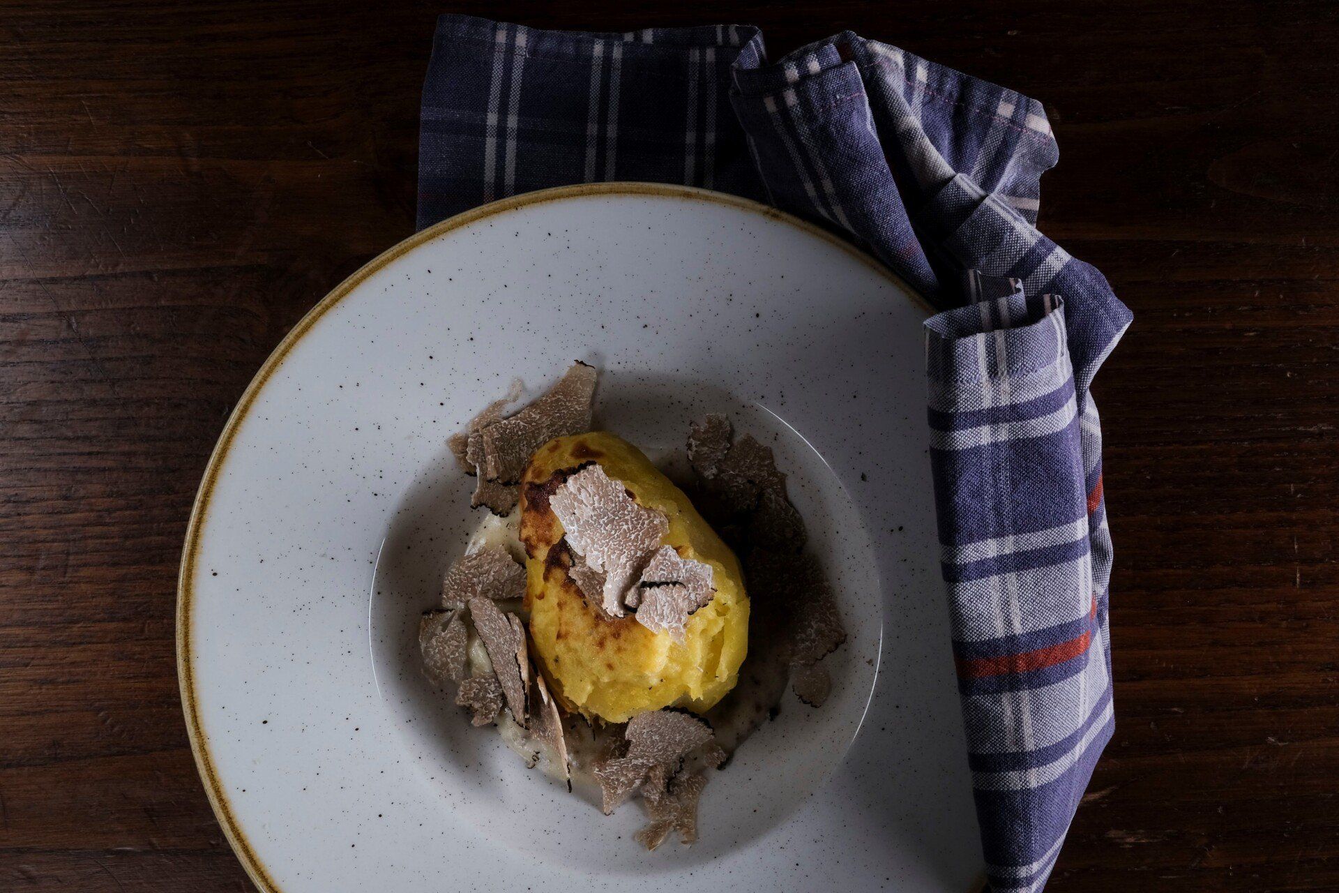 Patata ripiena di uovo, nocciole salate, fonduta di parmigiano al tartufo e tartufo fresco in petali.
