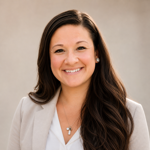Smiling woman in a light blazer and white top against a neutral background